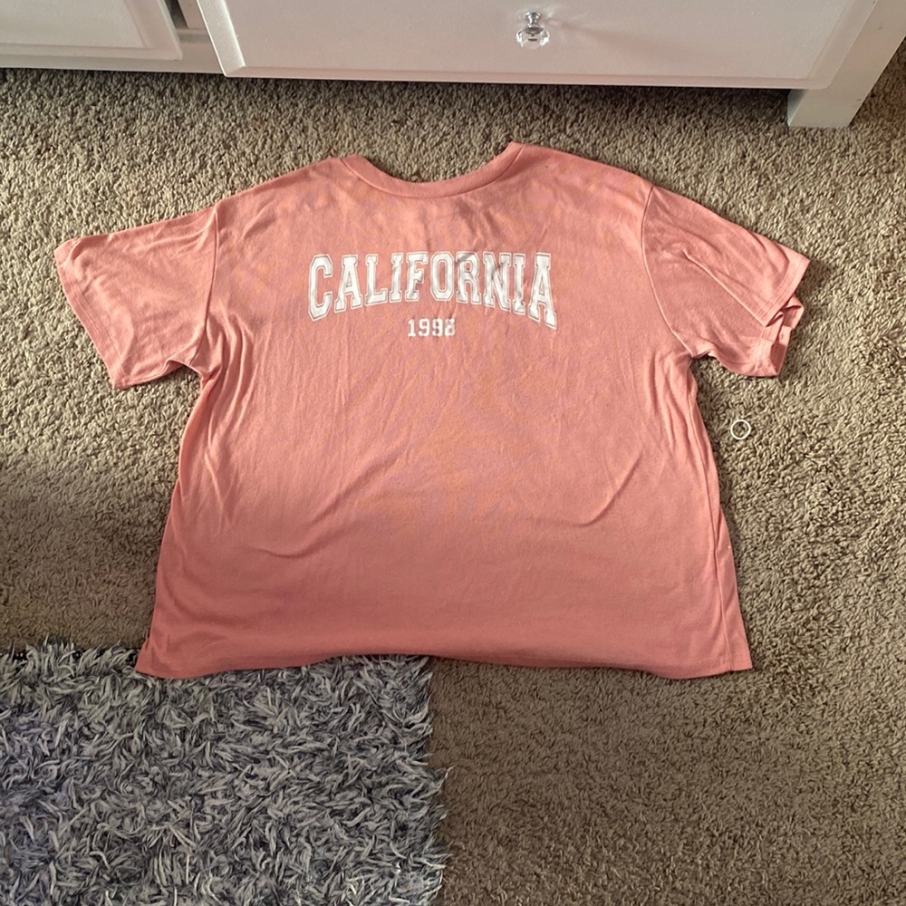 This is a coral/pink shirt with a white California font on the front.